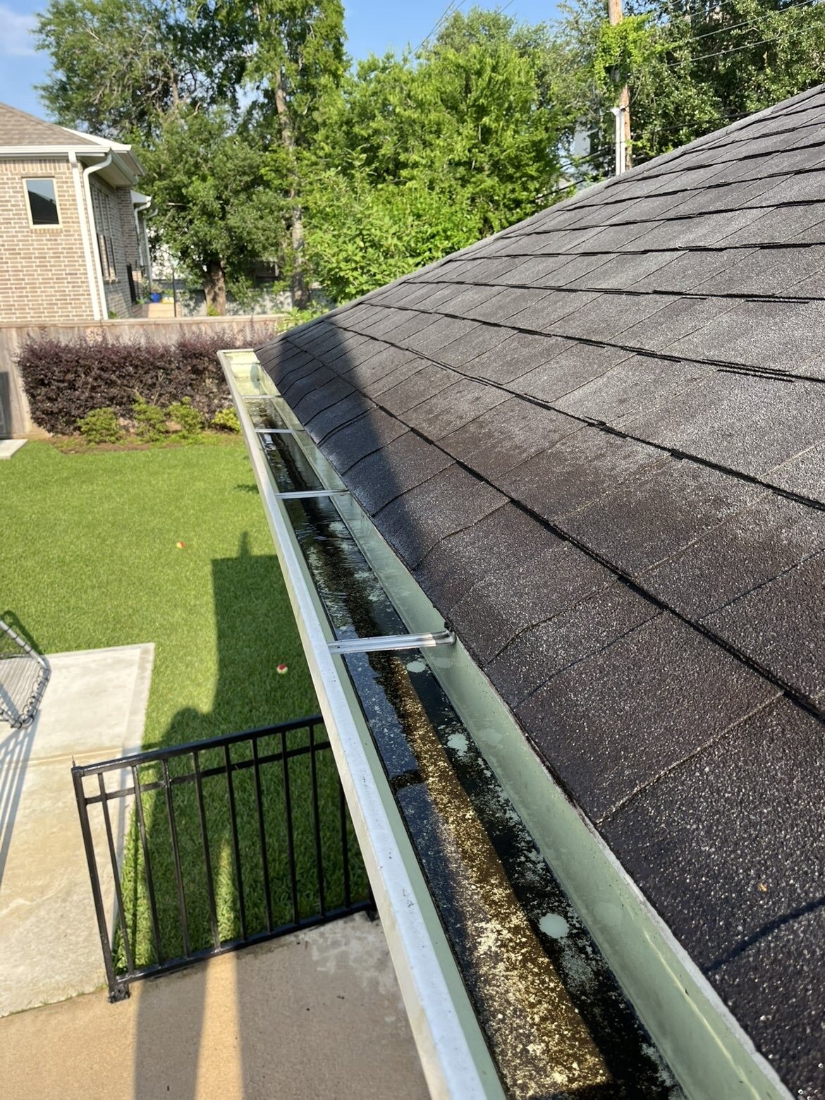 Gutter filled with leaves and organic debris before cleaning